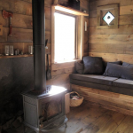 tiny-cabin-living-and-fireplace Interior of rustic tiny cabin